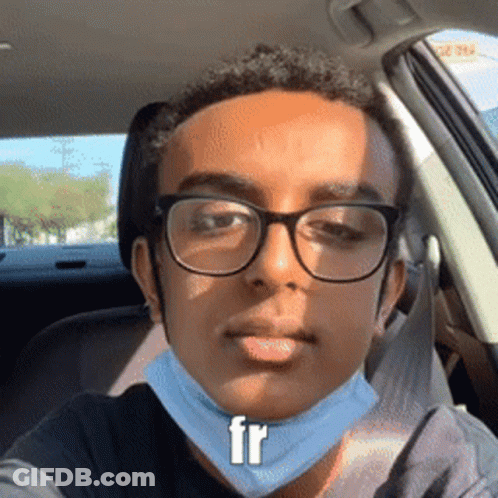 A Young Man Wearing Glasses And A Face Mask Is Sitting In A Car GIF