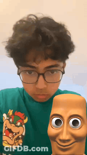 A Young Man Wearing Glasses And A Green Shirt With A Bowser On It GIF