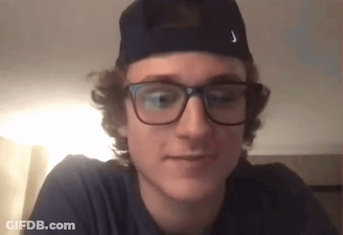 A Young Man Wearing Glasses And A Hat Has The Letter J On His Hat GIF