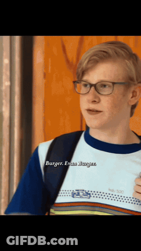A Young Man Wearing Glasses And A Shirt That Says Burger GIF