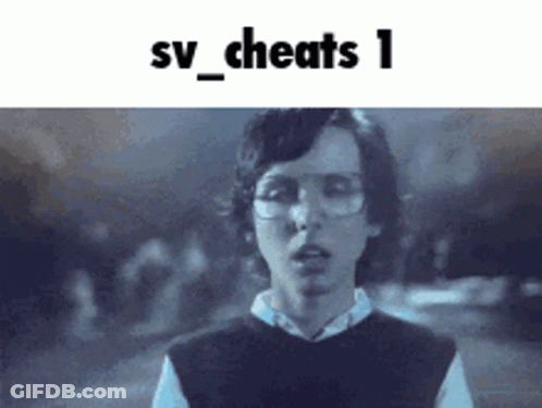 A Young Man Wearing Glasses And A Vest Is Standing In Front Of A Sign That Says Sv_cheats 1 GIF