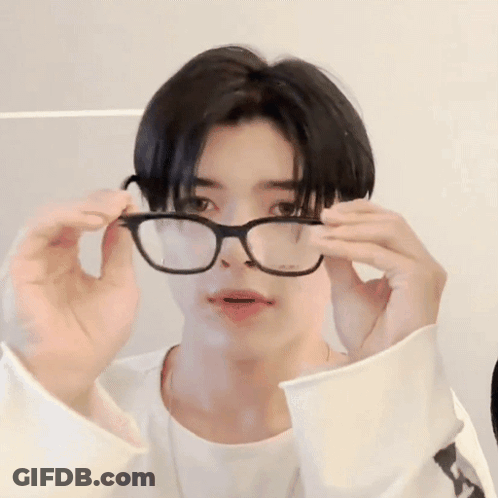 A Young Man Wearing Glasses And A White Shirt Is Making A Funny Face . GIF