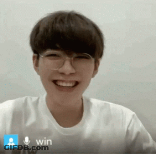 A Young Man Wearing Glasses And A White Shirt Is Smiling In Front Of A Microphone That Says Win GIF
