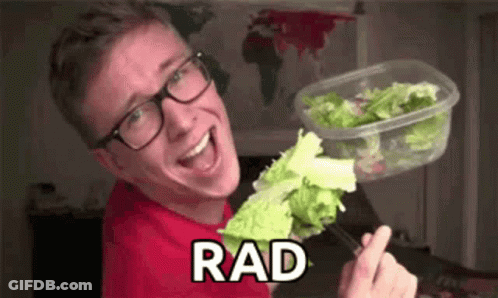 A Young Man Wearing Glasses Is Holding A Container Of Lettuce And A Fork . GIF