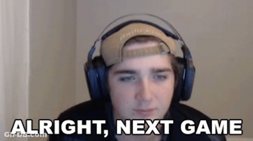 A Young Man Wearing Headphones And A Baseball Cap Is Sitting In Front Of A Computer Screen . GIF