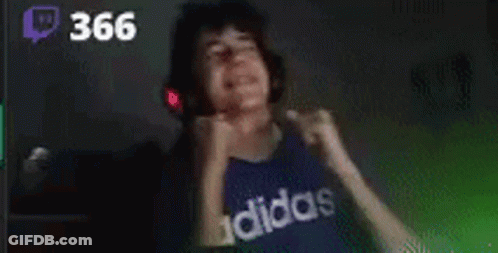 A Young Man Wearing Headphones And A Blue Adidas Shirt Is Dancing In A Dark Room . GIF