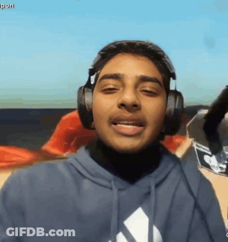 A Young Man Wearing Headphones And A Blue Adidas Shirt GIF