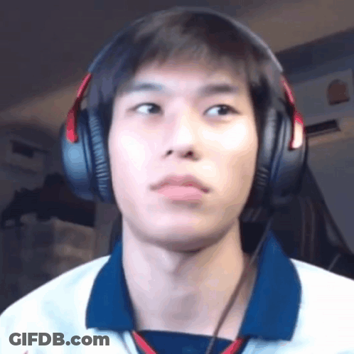 A Young Man Wearing Headphones And A Blue Shirt Is Looking At The Camera . GIF