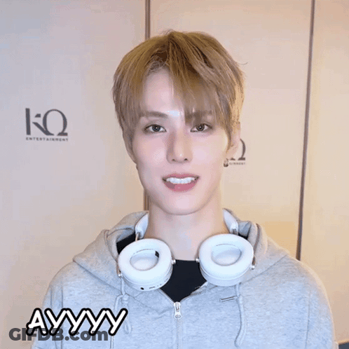 A Young Man Wearing Headphones And A Grey Hoodie Is Making A Funny Face And The Word Ayyy Is Above Him GIF
