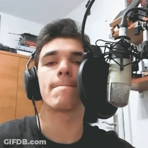 A Young Man Wearing Headphones And A Microphone GIF