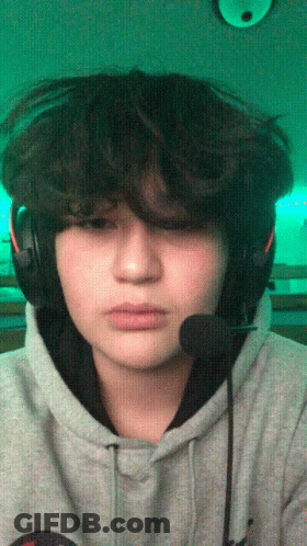 A Young Man Wearing Headphones And A Microphone Looks At The Camera GIF