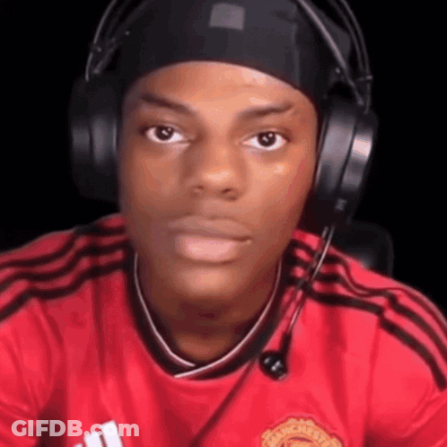 A Young Man Wearing Headphones And A Red Shirt Is Making A Funny Face . GIF