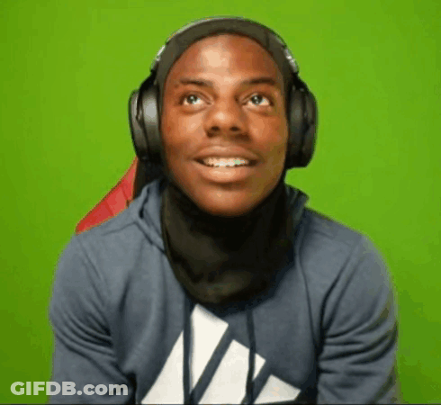 A Young Man Wearing Headphones And A Scarf Around His Neck Is Smiling . GIF
