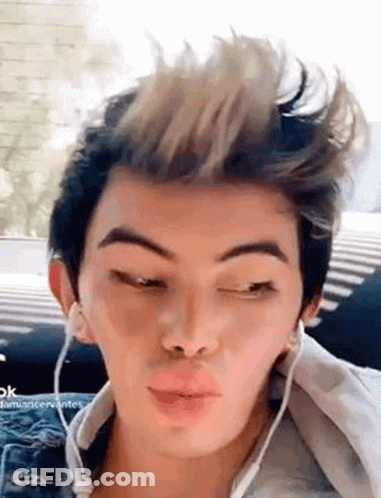 A Young Man Wearing Headphones And Making A Funny Face . GIF
