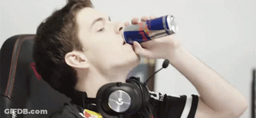 A Young Man Wearing Headphones Is Drinking A Red Bull Can GIF