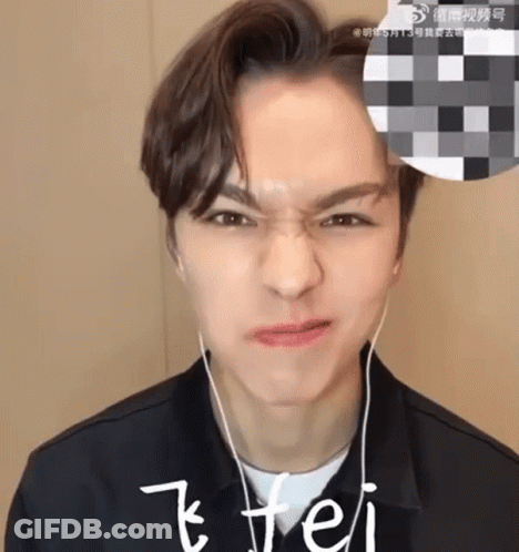 A Young Man Wearing Headphones Is Making A Face . GIF