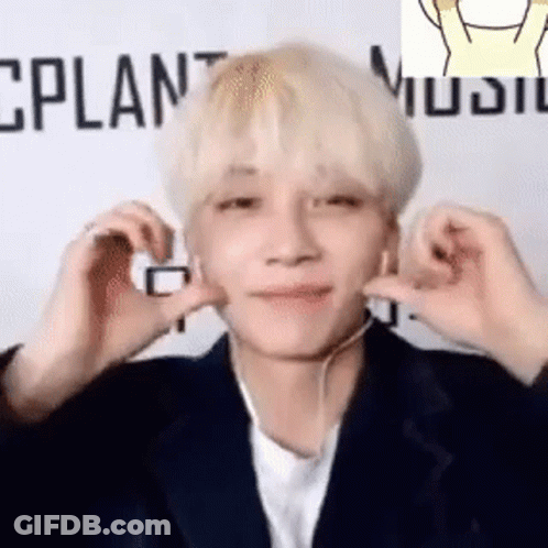 A Young Man Wearing Headphones Is Making A Heart Shape With His Hands . GIF
