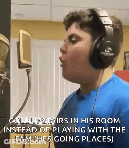 A Young Man Wearing Headphones Is Singing Into A Microphone .. GIF