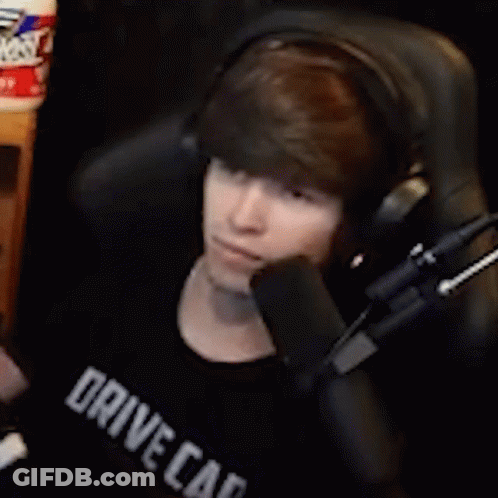 A Young Man Wearing Headphones Is Sitting In Front Of A Microphone And Talking Into It . GIF