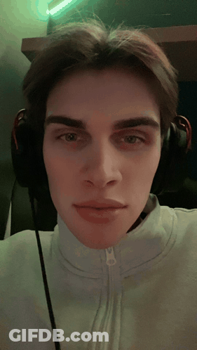 A Young Man Wearing Headphones Is Taking A Picture Of Himself GIF
