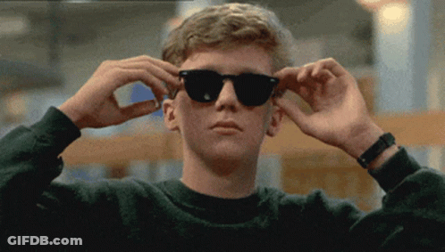 A Young Man Wearing Sunglasses Adjusts His Glasses GIF