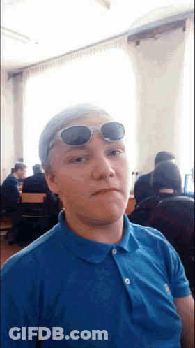 A Young Man Wearing Sunglasses And A Blue Shirt GIF