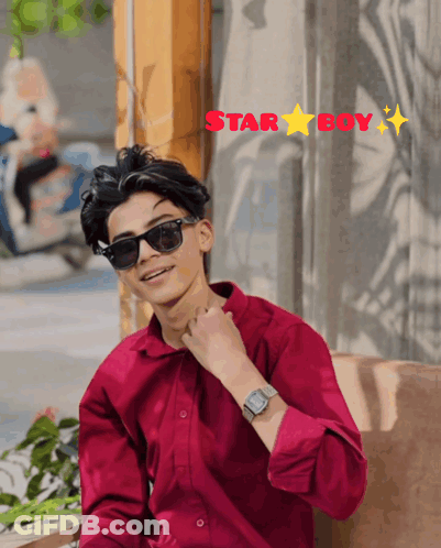 A Young Man Wearing Sunglasses And A Red Shirt Is Sitting In Front Of A Window With The Words Star Boy Above Him GIF