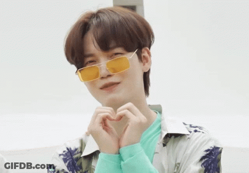 A Young Man Wearing Yellow Sunglasses Makes A Heart Shape With His Hands GIF