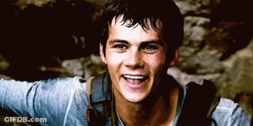 A Young Man With A Backpack Is Smiling And Looking At The Camera GIF