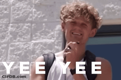 A Young Man With A Backpack Is Smiling In Front Of A Brick Wall With Yee Yee Written In White Letters GIF