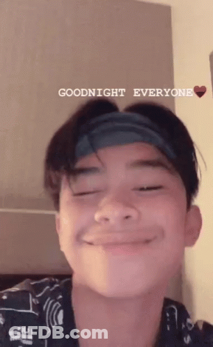 A Young Man With A Headband On His Head Is Smiling And Saying Goodnight Everyone . GIF