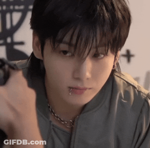 A Young Man With A Piercing In His Lip Is Holding A Camera . GIF