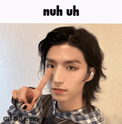 A Young Man With A Plaid Shirt Is Making A Funny Face With The Words Nuh Uh Above Him GIF