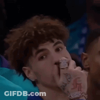 A Young Man With A Tattoo On His Wrist Is Sitting In A Crowd Watching A Game . GIF