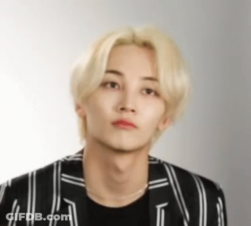 A Young Man With Blonde Hair And Red Lipstick Is Wearing A Black And White Striped Jacket And A Black Shirt . GIF