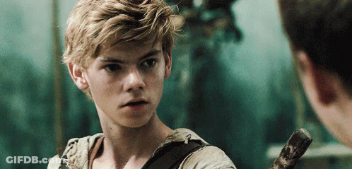 A Young Man With Blonde Hair Is Holding A Sword And Looking At Another Man . GIF