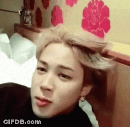 A Young Man With Blonde Hair Is Laying On A Bed With His Hair Blowing In The Wind . GIF