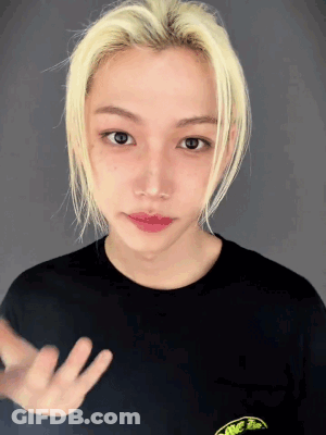A Young Man With Blonde Hair Is Wearing A Black T-Shirt With A Frog On It GIF