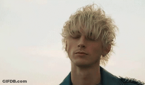 A Young Man With Blonde Hair Is Wearing A Leather Jacket And A Black Shirt . GIF
