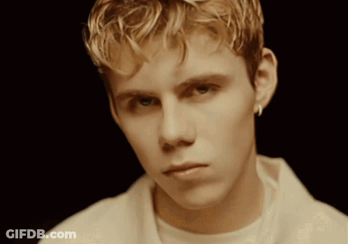 A Young Man With Blonde Hair Is Wearing A White Shirt GIF