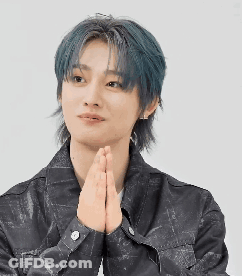 A Young Man With Blue Hair Is Holding His Hands Together In Prayer . GIF