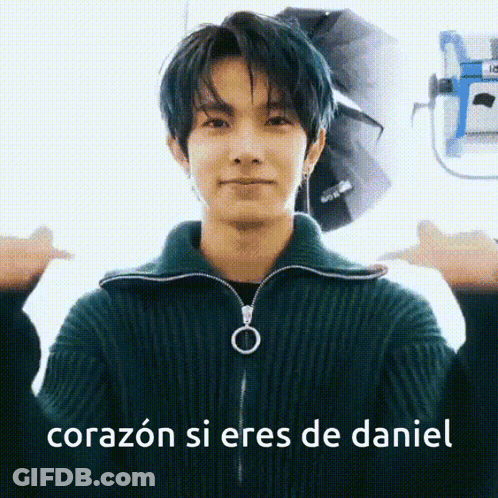 A Young Man With Blue Hair Is Wearing A Green Sweater And Making A Thumbs Up Sign . GIF