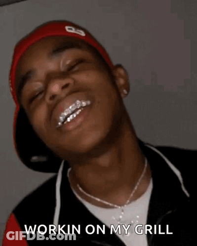A Young Man With Braces On His Teeth Is Smiling With His Eyes Closed And Says `` Workin On My Grill '' . GIF
