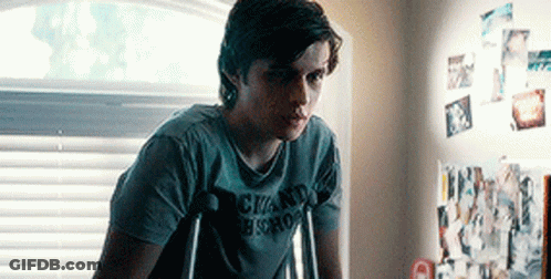 A Young Man With Crutches Is Wearing A Shirt That Says Chand Bistro . GIF