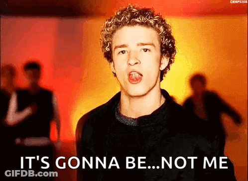 A Young Man With Curly Hair Is Singing In Front Of A Crowd . GIF