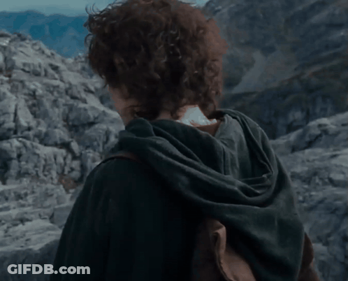 A Young Man With Curly Hair Is Standing In Front Of Mountains GIF