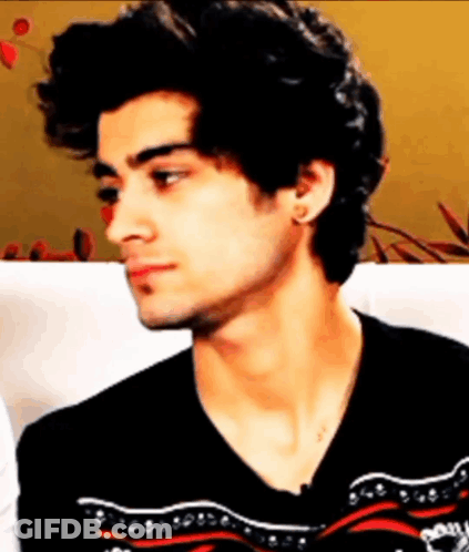 A Young Man With Curly Hair Is Wearing A Black Sweater GIF