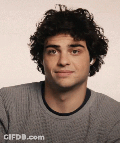 A Young Man With Curly Hair Is Wearing A Gray Sweater GIF