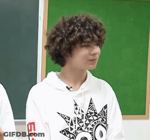 A Young Man With Curly Hair Is Wearing A Hoodie With A Star On It . GIF