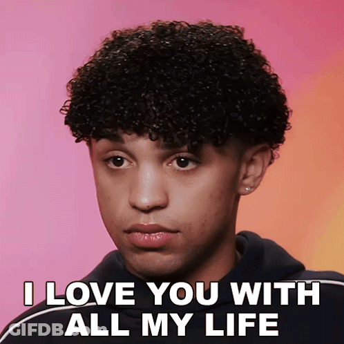 A Young Man With Curly Hair Says I Love You With All My Life On A Pink Background GIF
